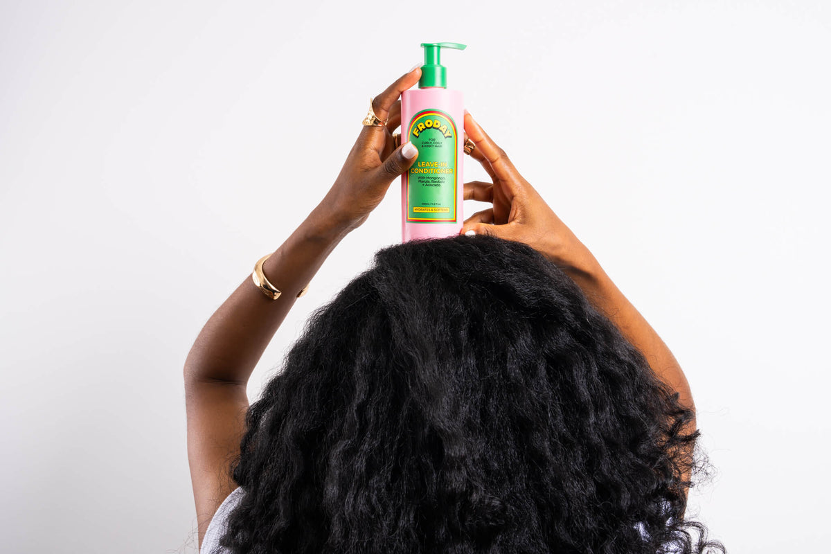 Froday hydrating leave-in conditioner held above natural curly hair